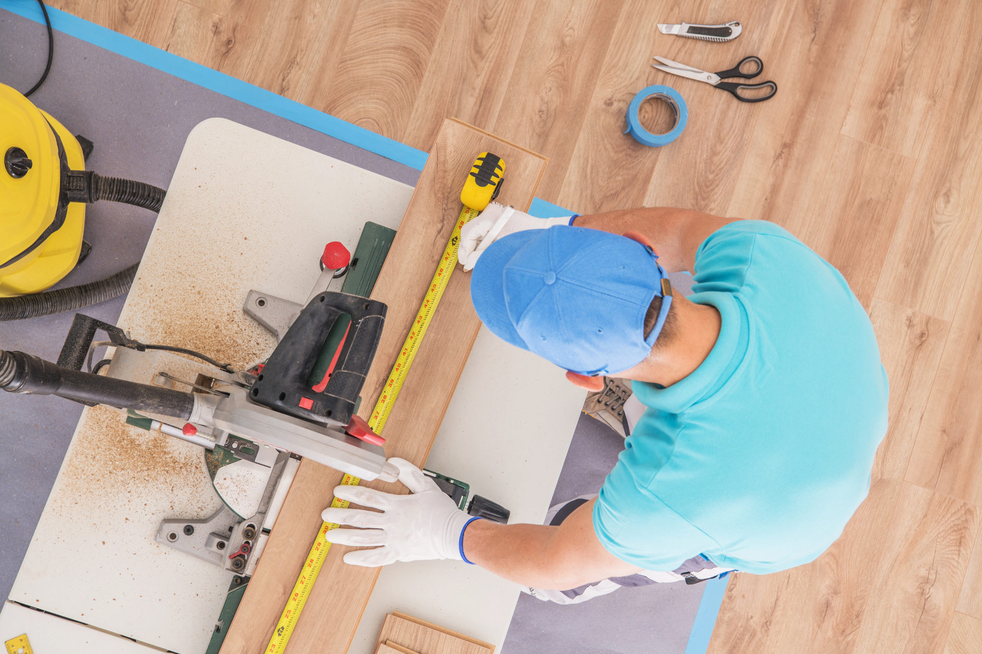 A man is cutting a piece of wood with a circular saw.