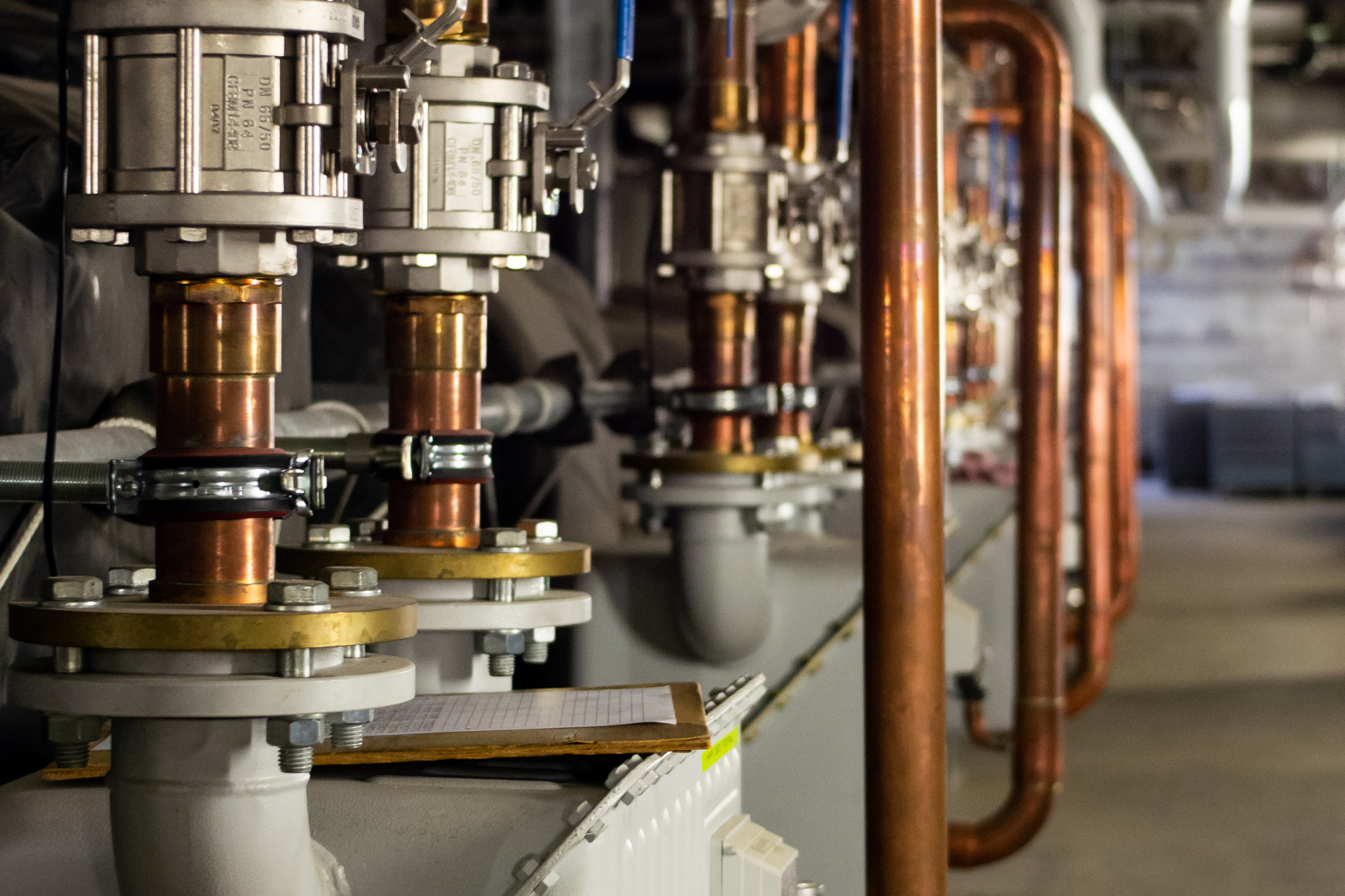 A row of copper pipes are lined up in a factory.