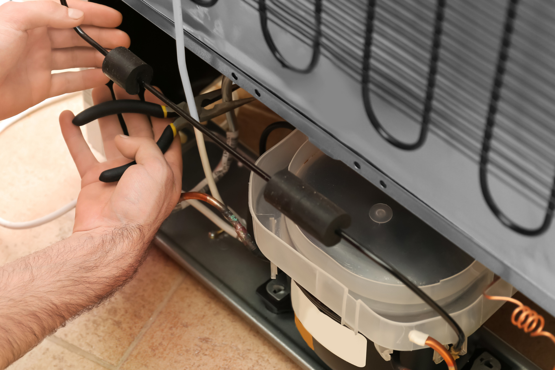 A man is working on the inside of a refrigerator.
