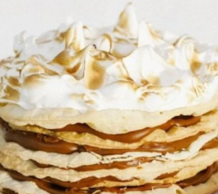 Torta en capas con dulce de leche y cobertura de merengue.