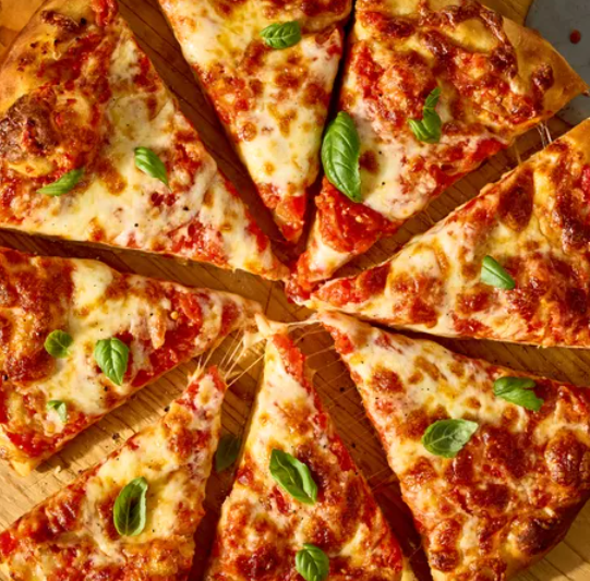 Pizza cortada en ocho porciones, cubierta con queso, salsa de tomate y hojas de albahaca.