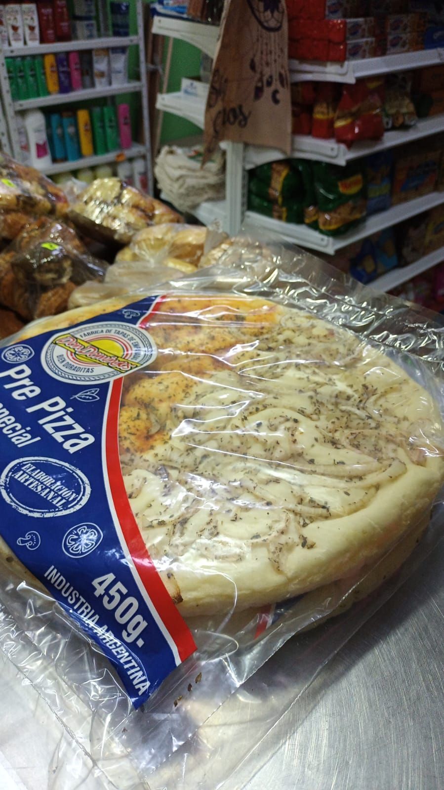 Pizza preparada y envasada en una tienda, lista para hornear.