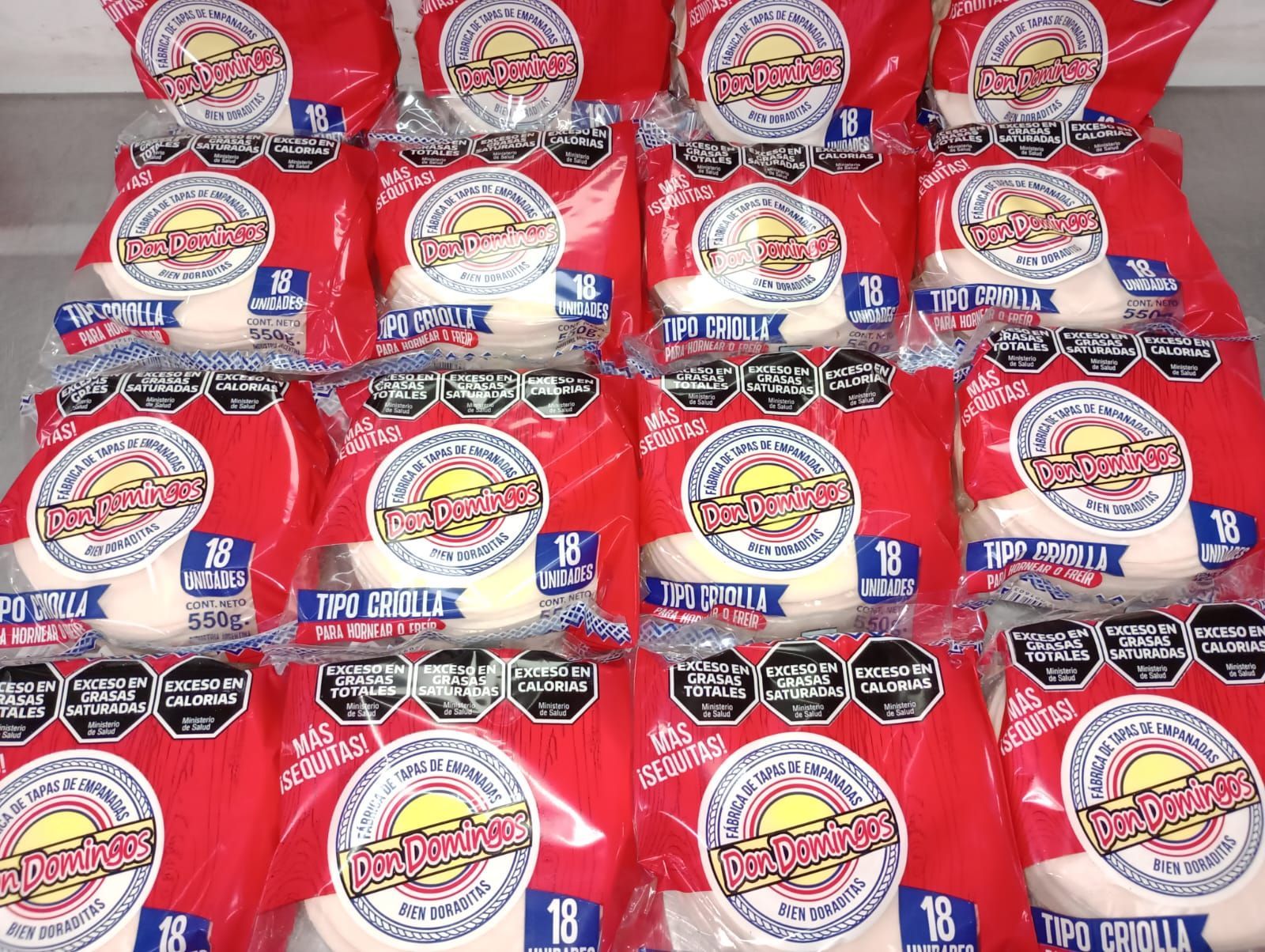 Pilas de paquetes de tortillas envueltos en rojo con logotipos.