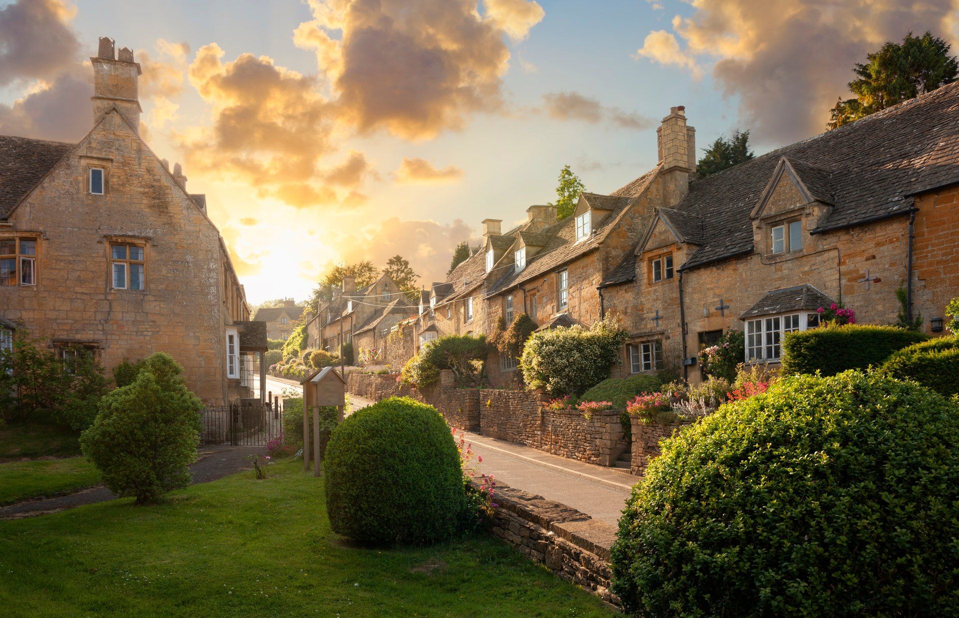 A row of houses in a village with a sunset in the background.