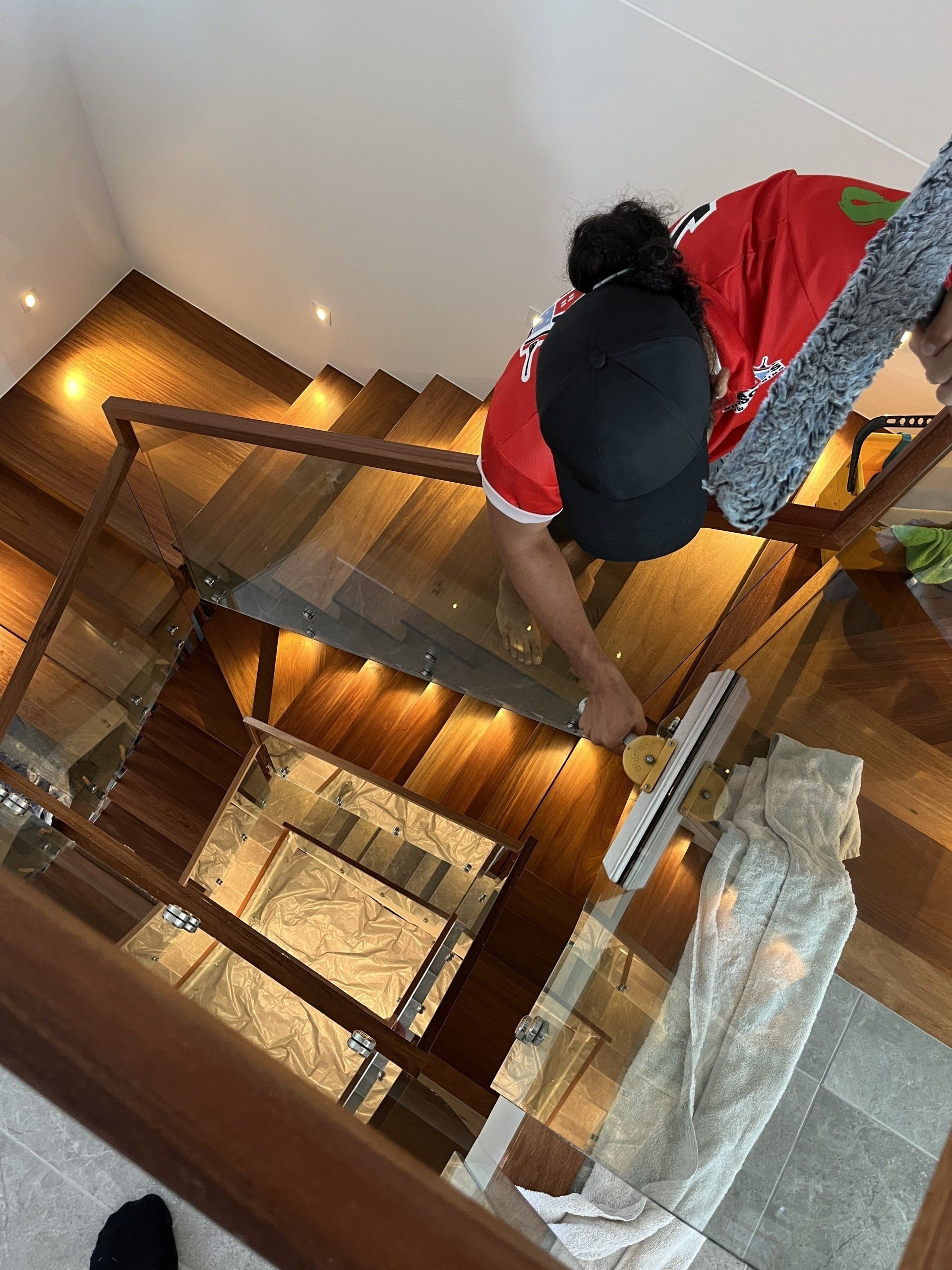 Worker Cleaning Balcony Glass — Jackson’s Window Cleaning in Nerang, QLD