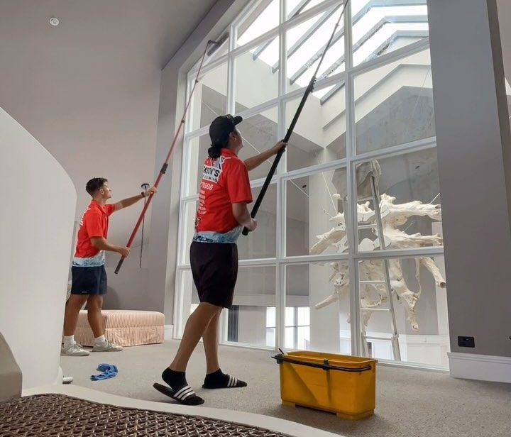 Professional window cleaners cleaning difficult to reach windows.