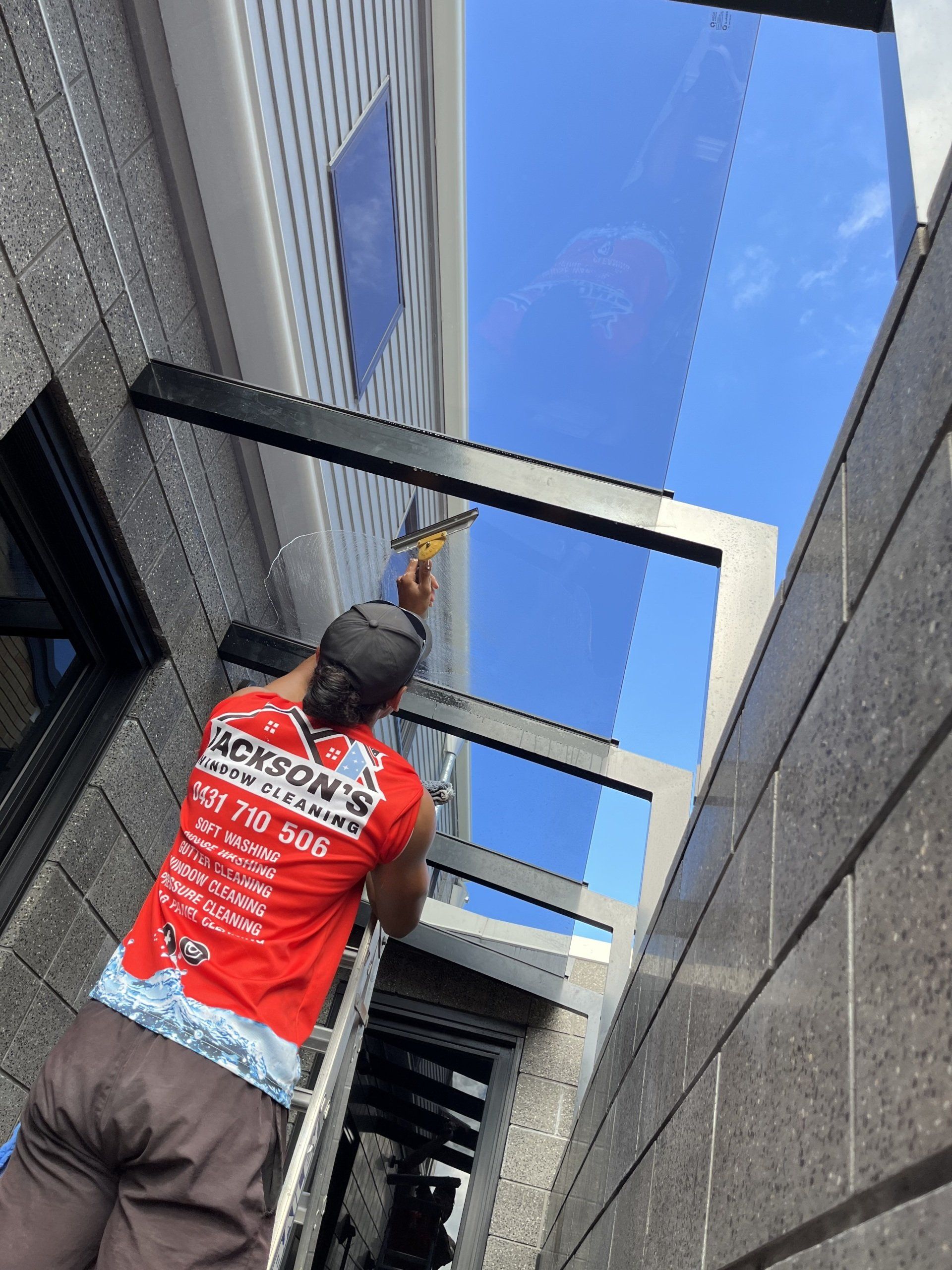 Glass Panels Being Cleaned — Jackson’s Window Cleaning in Nerang, QLD