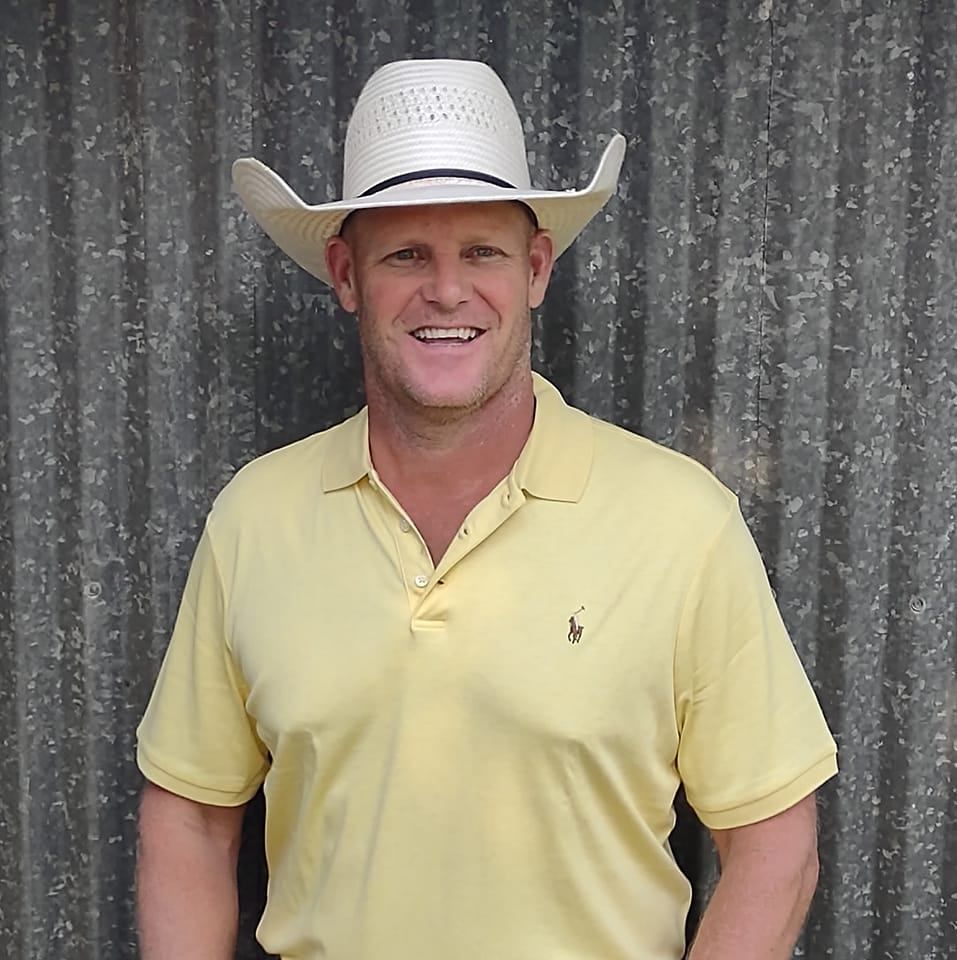 a man wearing a cowboy hat and a yellow shirt
