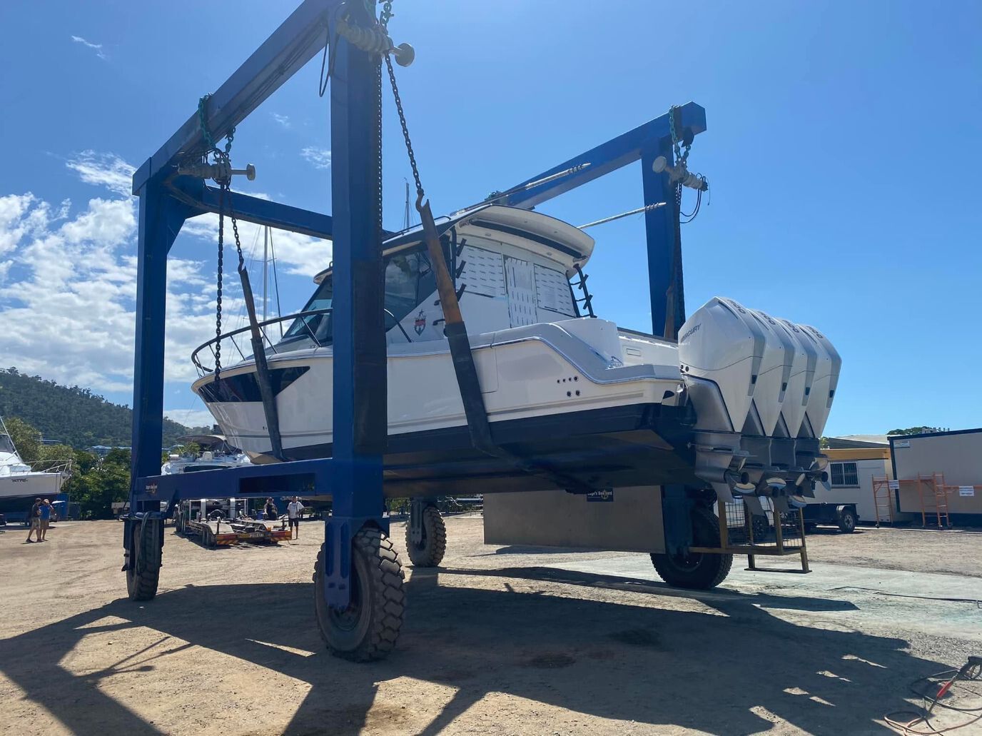 A Boat Is Being Lifted By A Crane In A Parking Lot — Edge's Boatyard In Airlie Beach, QLD