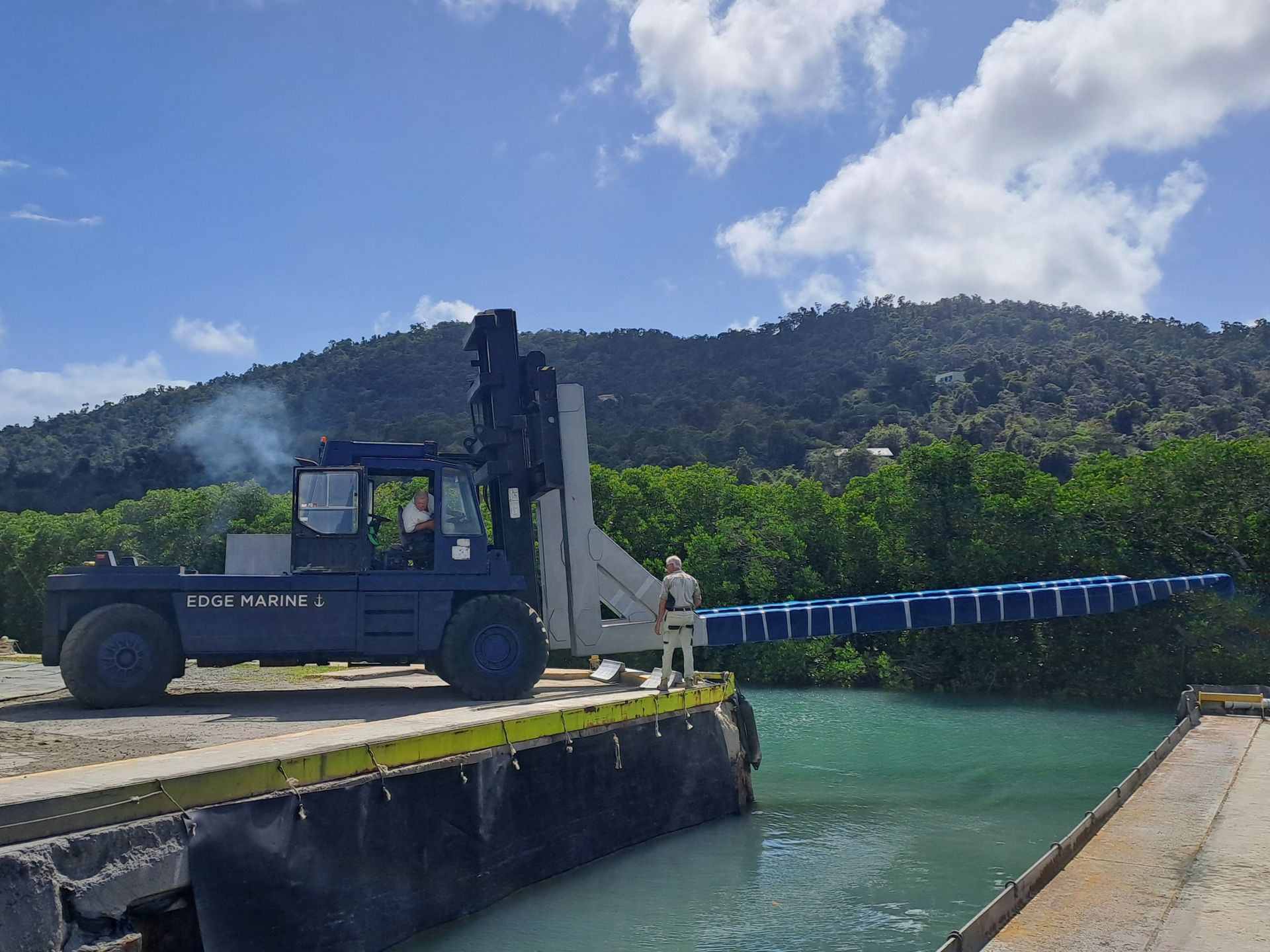 A forklift is sitting on a dock next to a body of water — Edge's Boatyard In Jubilee Pocket, QLD