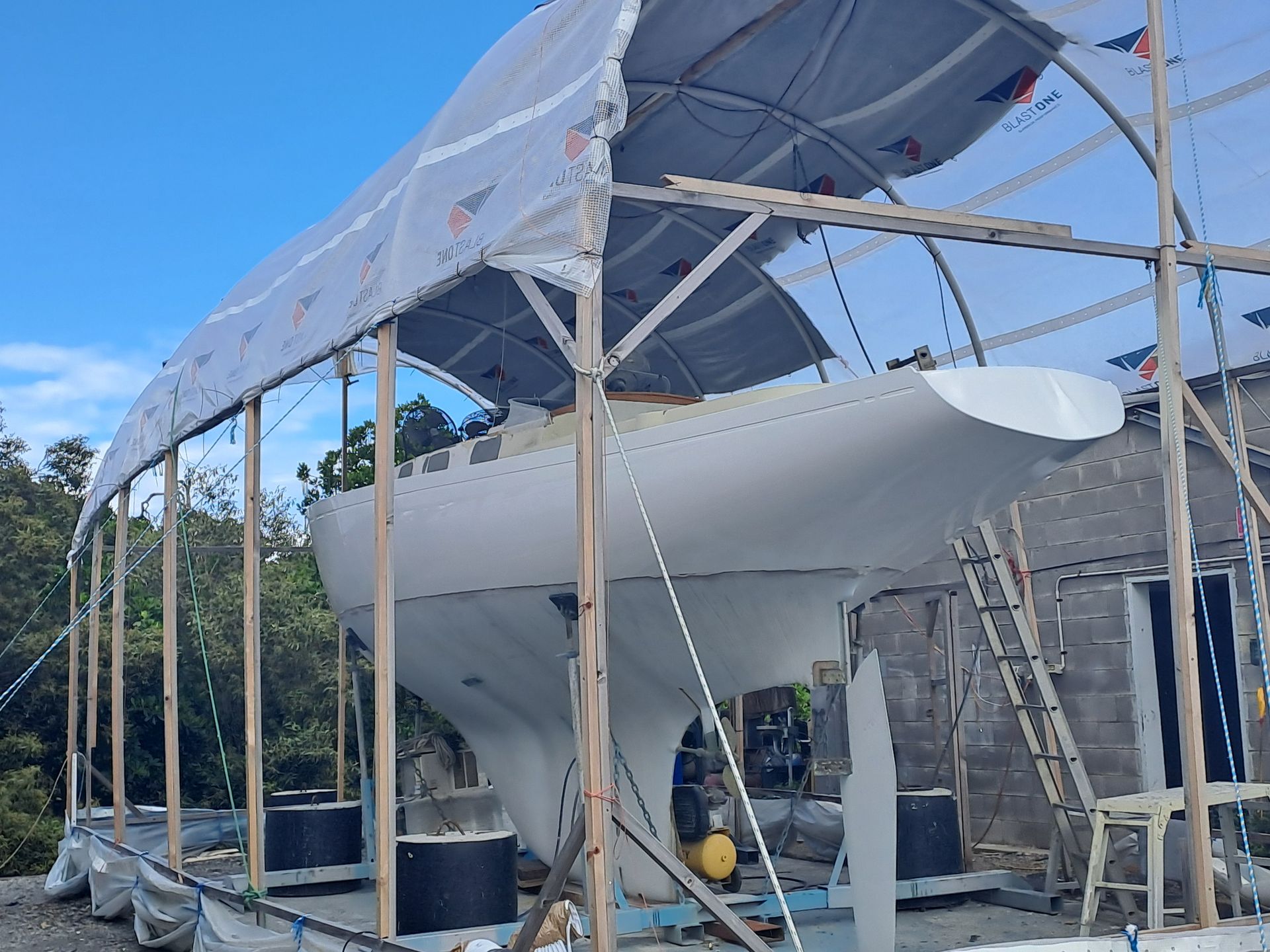 A White Boat With A Green Trim Is Being Painted — Edge's Boatyard In Jubilee Pocket, QLD