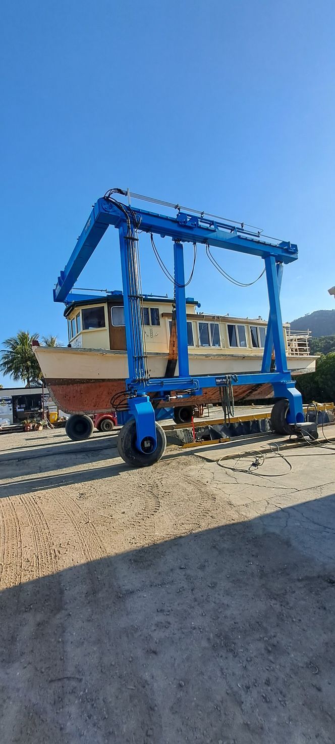 A Boat Is Being Lifted By A Crane In A Marina — Edge's Boatyard In Jubilee Pocket, QLD