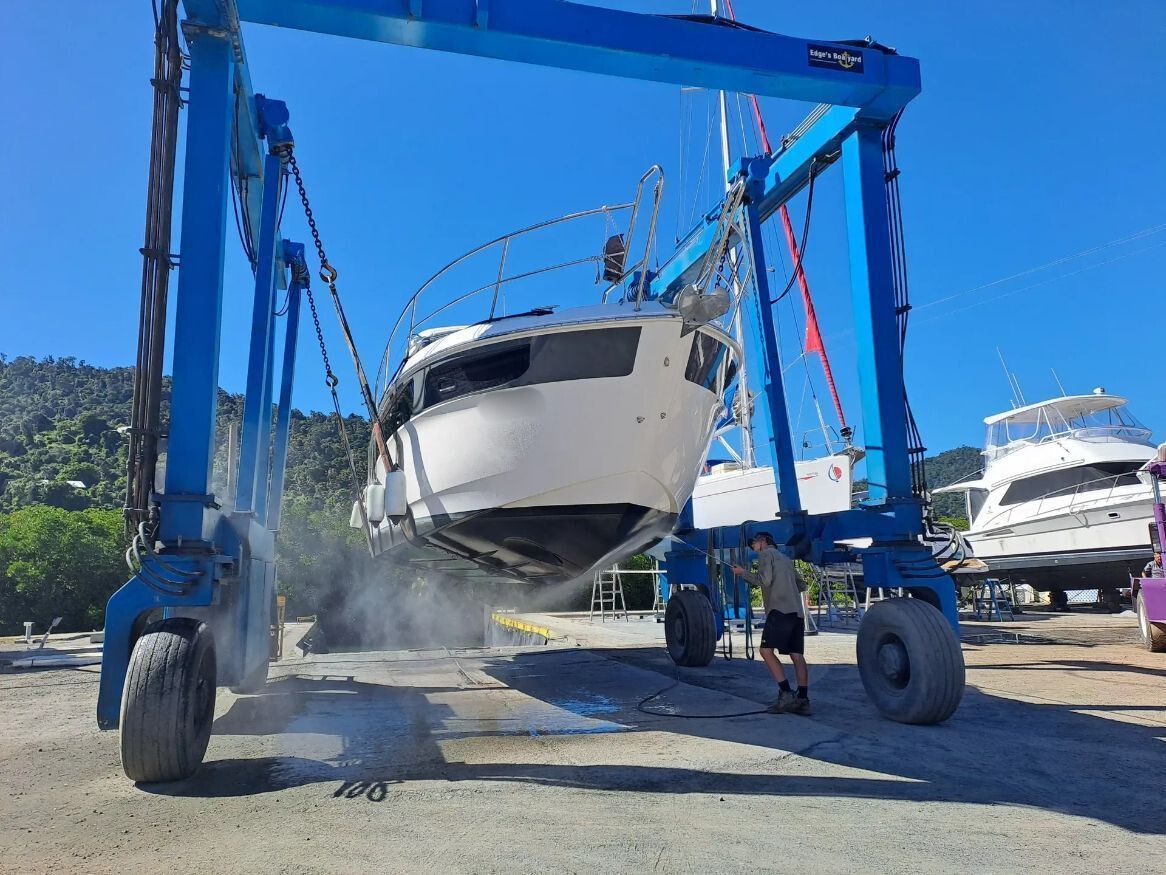 A Boat Is Being Lifted By A Crane In A Marina — Edge's Boatyard In Jubilee Pocket, QLD