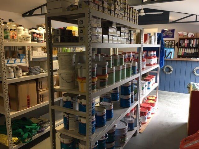 A Store Filled With Shelves Filled With Lots Of Paints — Edge's Boatyard In Airlie Beach, QLD