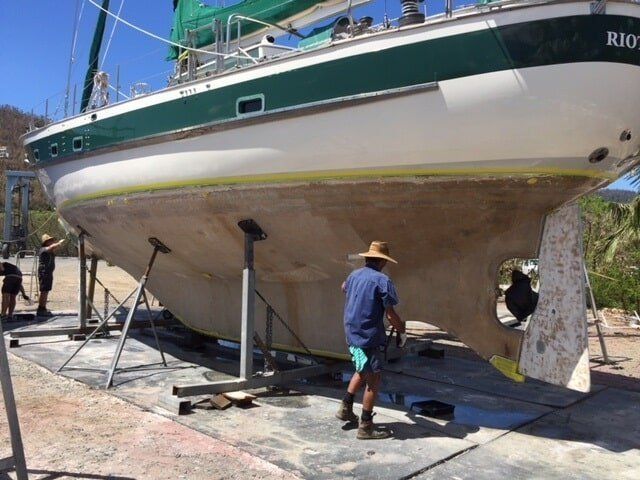 A Man In A Hat Is Standing Next To A Boat That Says Rio — Edge's Boatyard In Jubilee Pocket, QLD