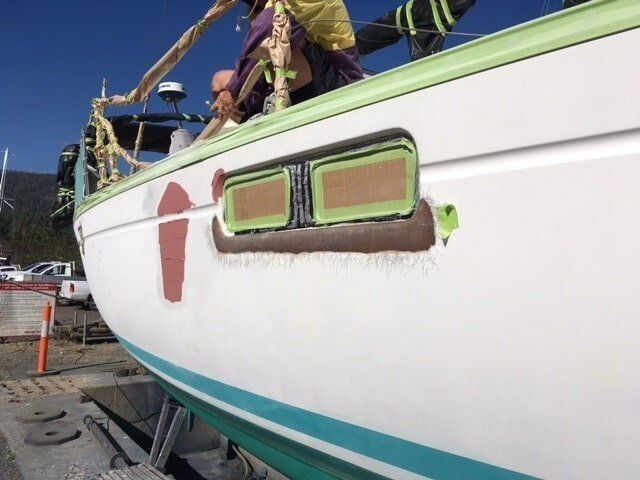 A White Boat With A Green Trim Is Being Painted — Edge's Boatyard In Airlie Beach, QLD