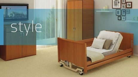 Camera da letto con letto regolabile, mobili in legno, pareti blu e opere d'arte.