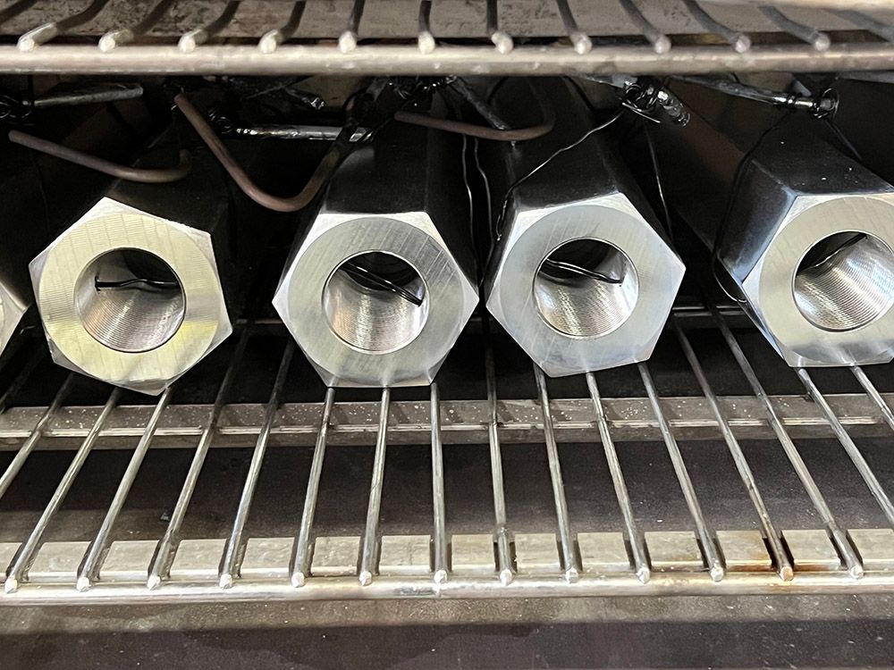 Large female standoffs being baked for hydrogen embrittlement relief by Seminole Metal Finishing.