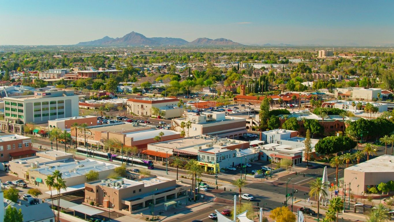 Flyover view of golf course with mountains in the background