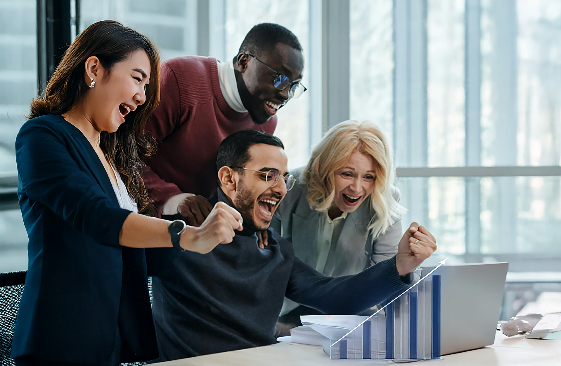Team cheers excitedly at a laptop showing a rising bar graph in a modern office.