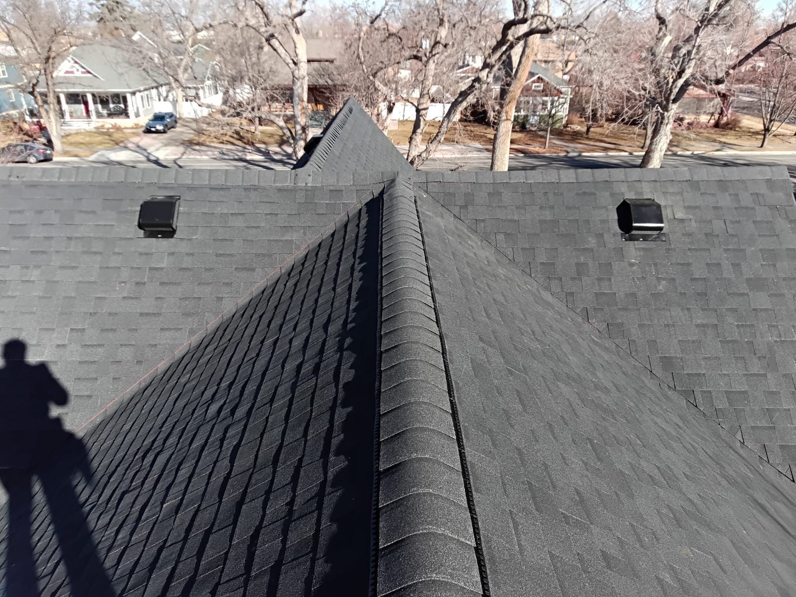 A roof with a shadow of a person standing on it.