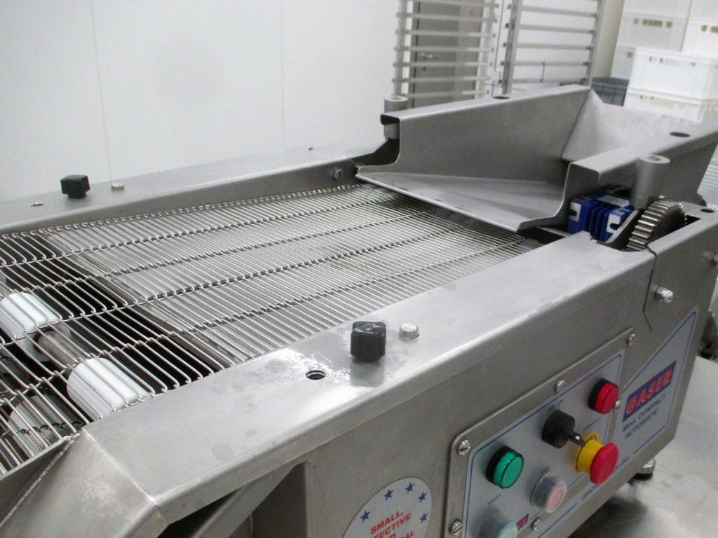 Lebensmittelverarbeitungsmaschine aus Edelstahl mit Drahtgewebeförderband und Bedienfeld.