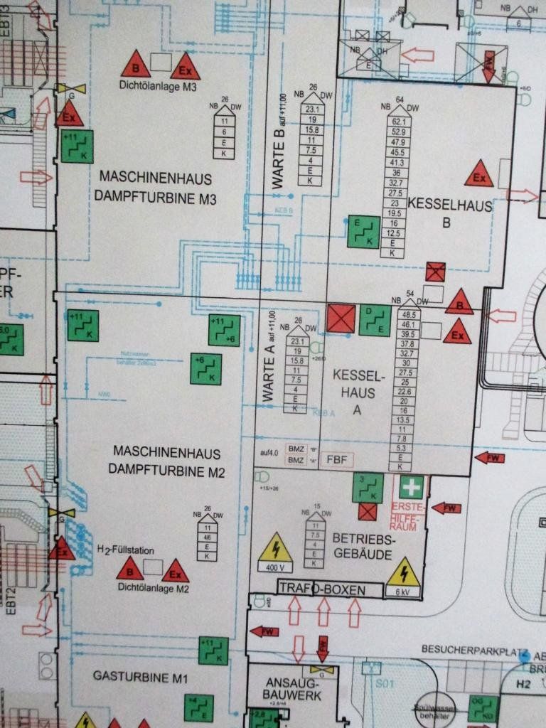 Schema eines Gebäudegrundrisses mit Beschriftungen, Sicherheitssymbolen und farbigen Markierungen zur Angabe der Standorte.