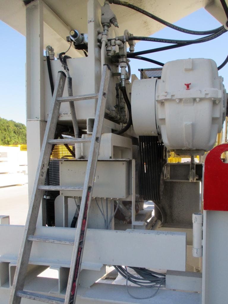 Weiße Industriemaschinen mit Leiter, Kabeln und roten Akzenten im Freien.