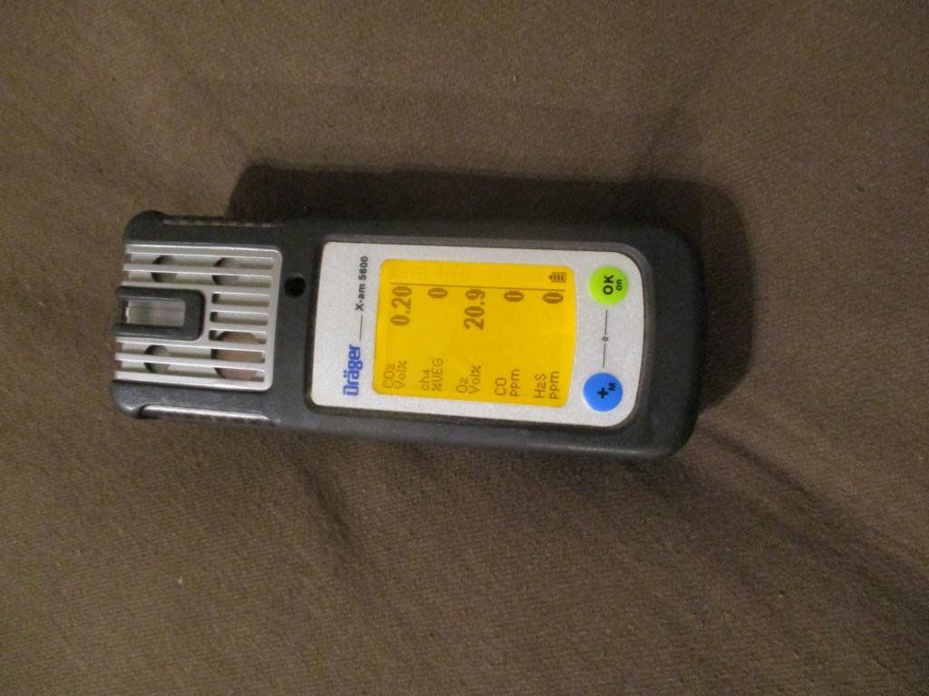 Ein Dräger X-am 2000 Mehrgasdetektor auf brauner Oberfläche, Display mit Gasmesswerten.