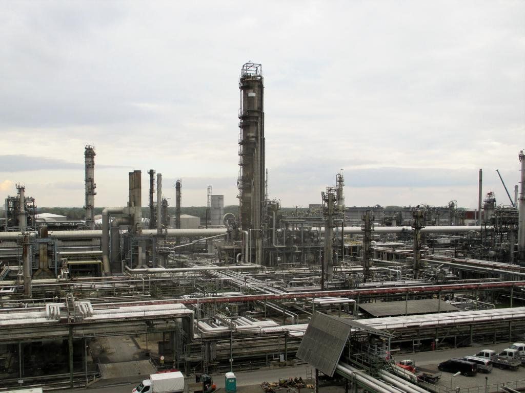 Industrieraffineriekomplex, ein Netzwerk aus Rohren, Türmen und Bauwerken unter bewölktem Himmel.