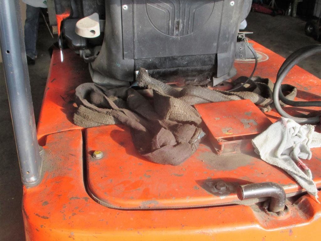 Oranger Gabelstapler mit schwarzem Sitz und schmutzigem Lappen darauf.