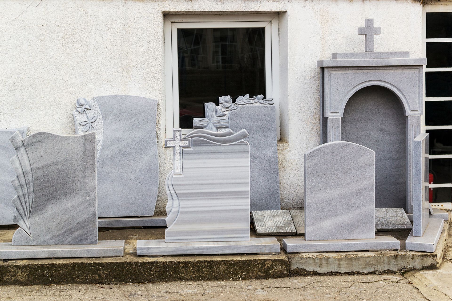 A row of gravestones are lined up in front of a building
