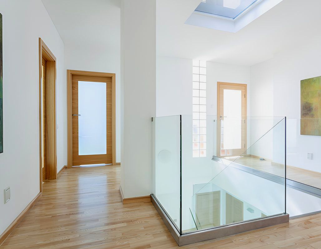 A Hallway With A Glass Railing Leading To A Staircase — Andrew Pye Painting & Decorating In Gillen, NT