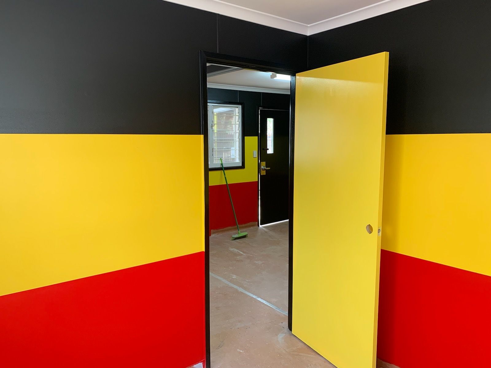 A Room With Red , Yellow And Black Walls And A Yellow Door — Andrew Pye Painting & Decorating In Gillen, NT