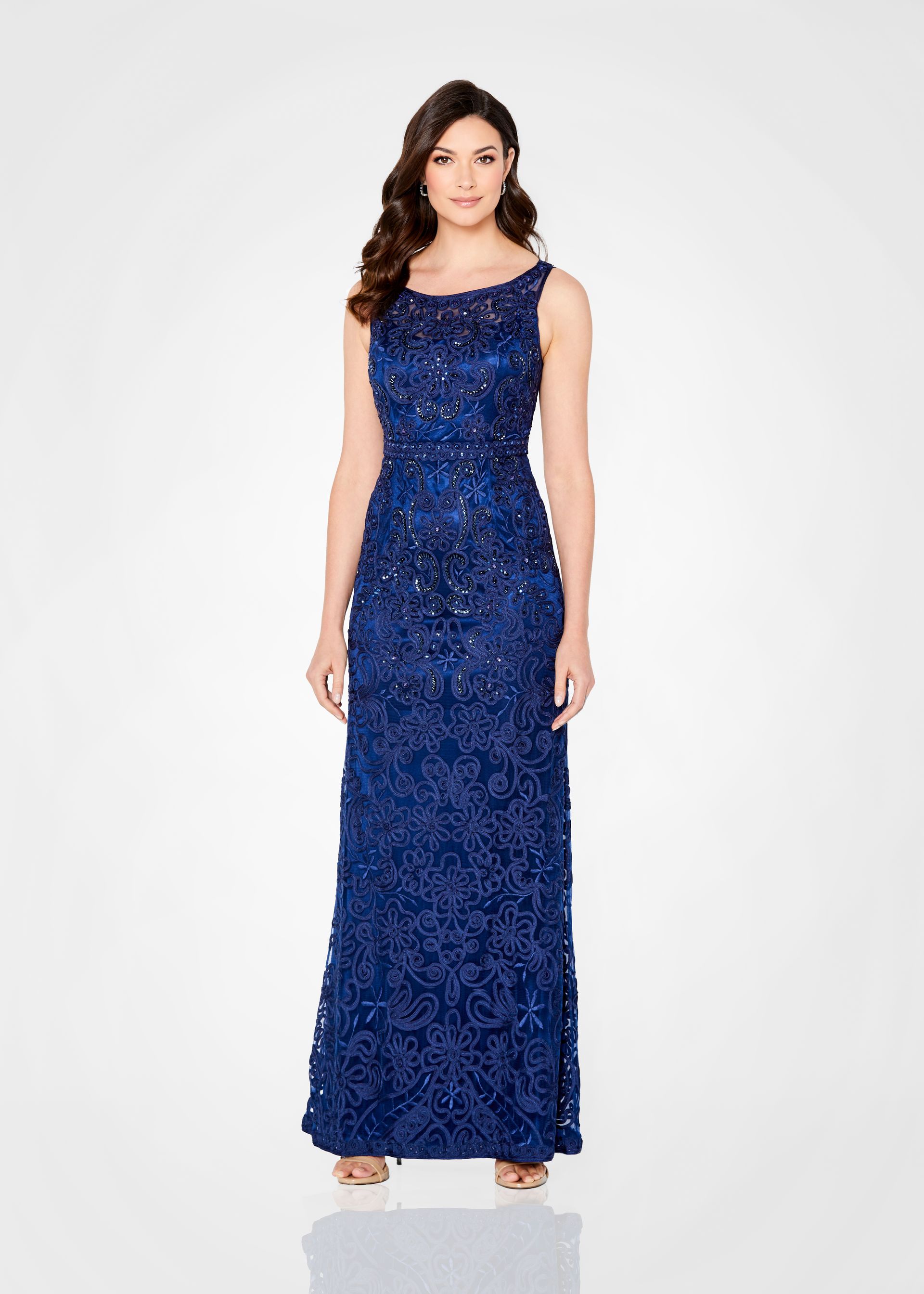 Woman in navy blue beaded evening gown, standing, studio shot. Woman in navy blue beaded evening gown, standing, studio shot.