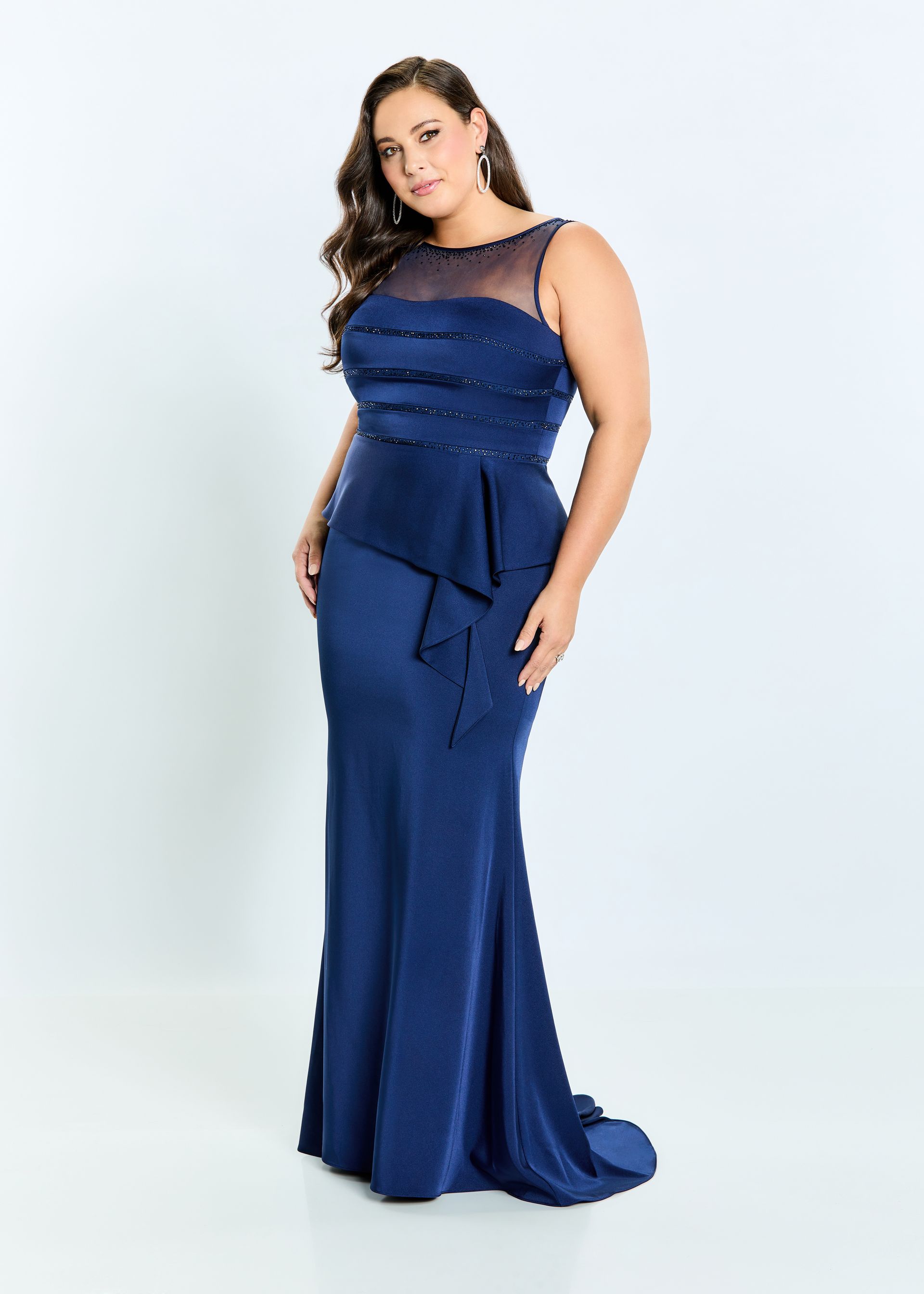 A plus size woman is wearing a long blue dress.