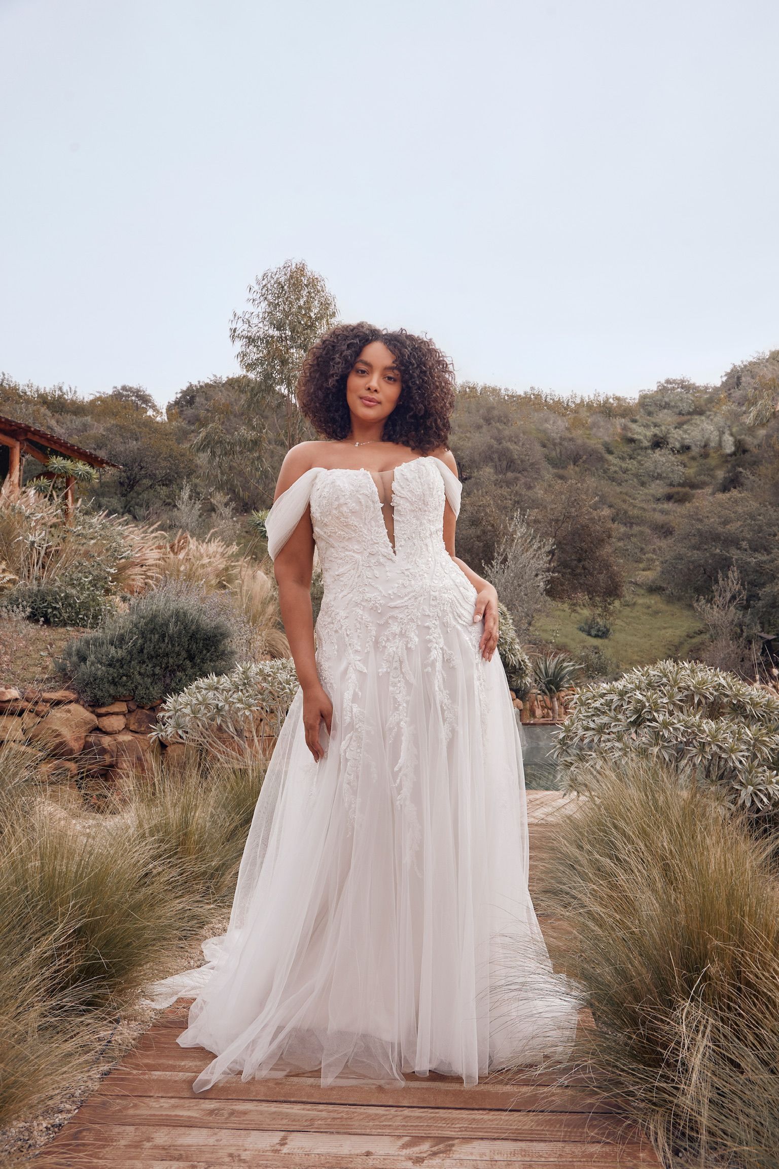 A woman in a white wedding dress is standing on a set of stairs.