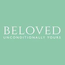 A woman in a Fifi's Bridal white wedding dress is standing in front of a fountain.