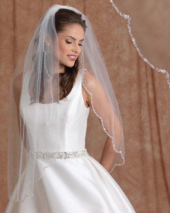 A woman in a wedding dress is wearing a veil