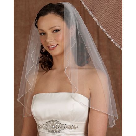 A woman in a wedding dress is wearing a veil.
