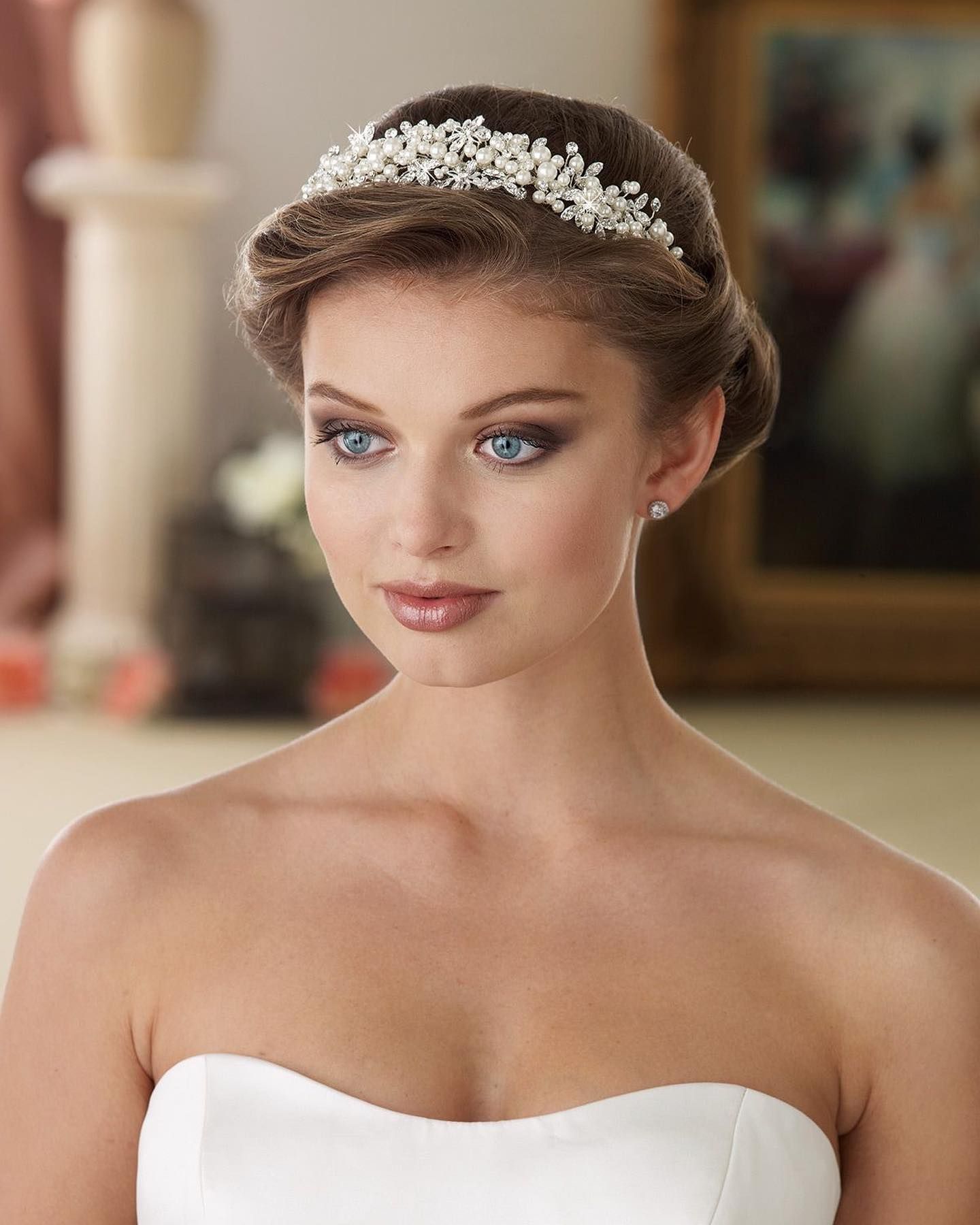 A woman in a wedding dress is wearing a tiara in her hair.