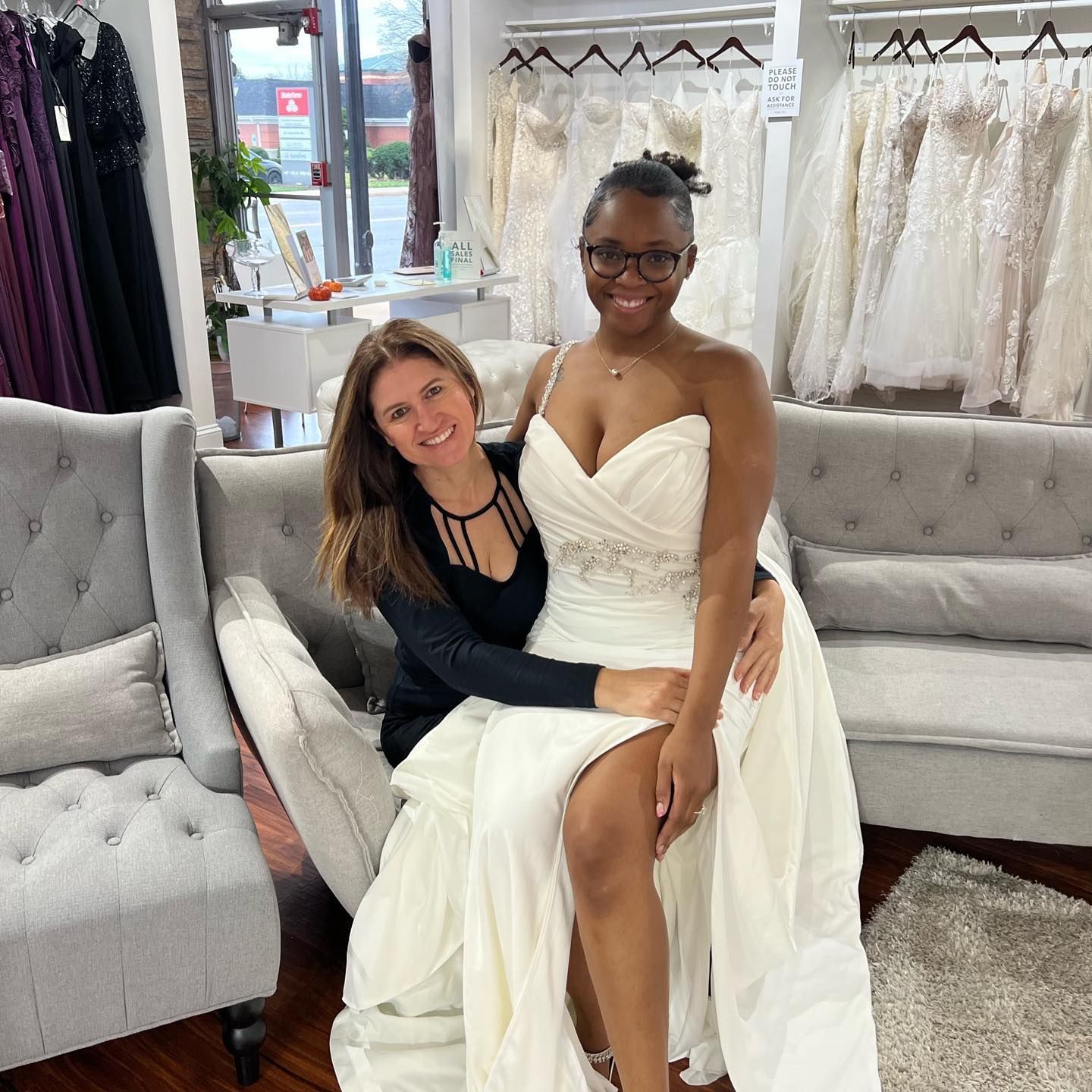 A woman in a wedding dress is sitting on a couch with another woman.