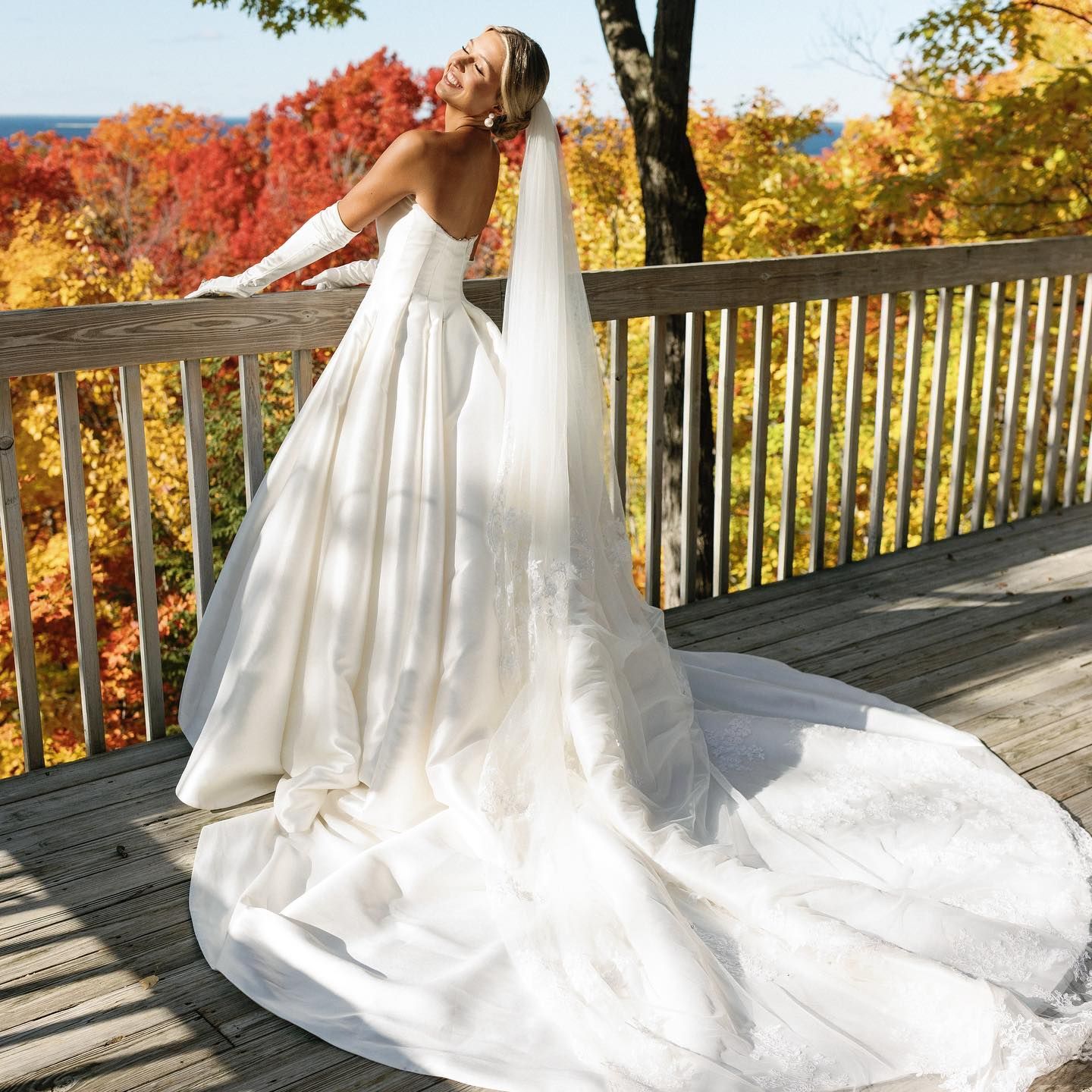 A woman in a wedding dress is standing on a deck