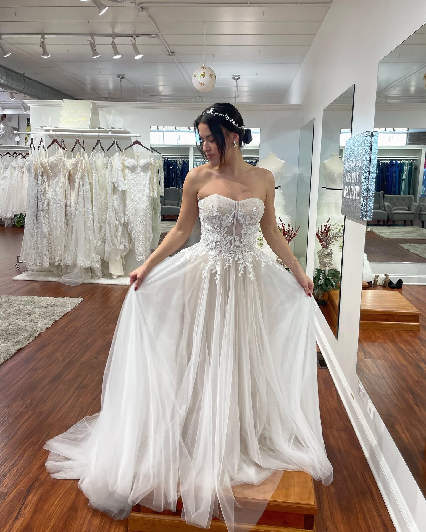 A woman is trying on a wedding dress in a bridal shop.