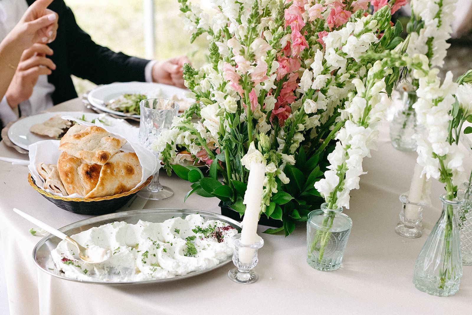 A table with plates of food and flowers on it.