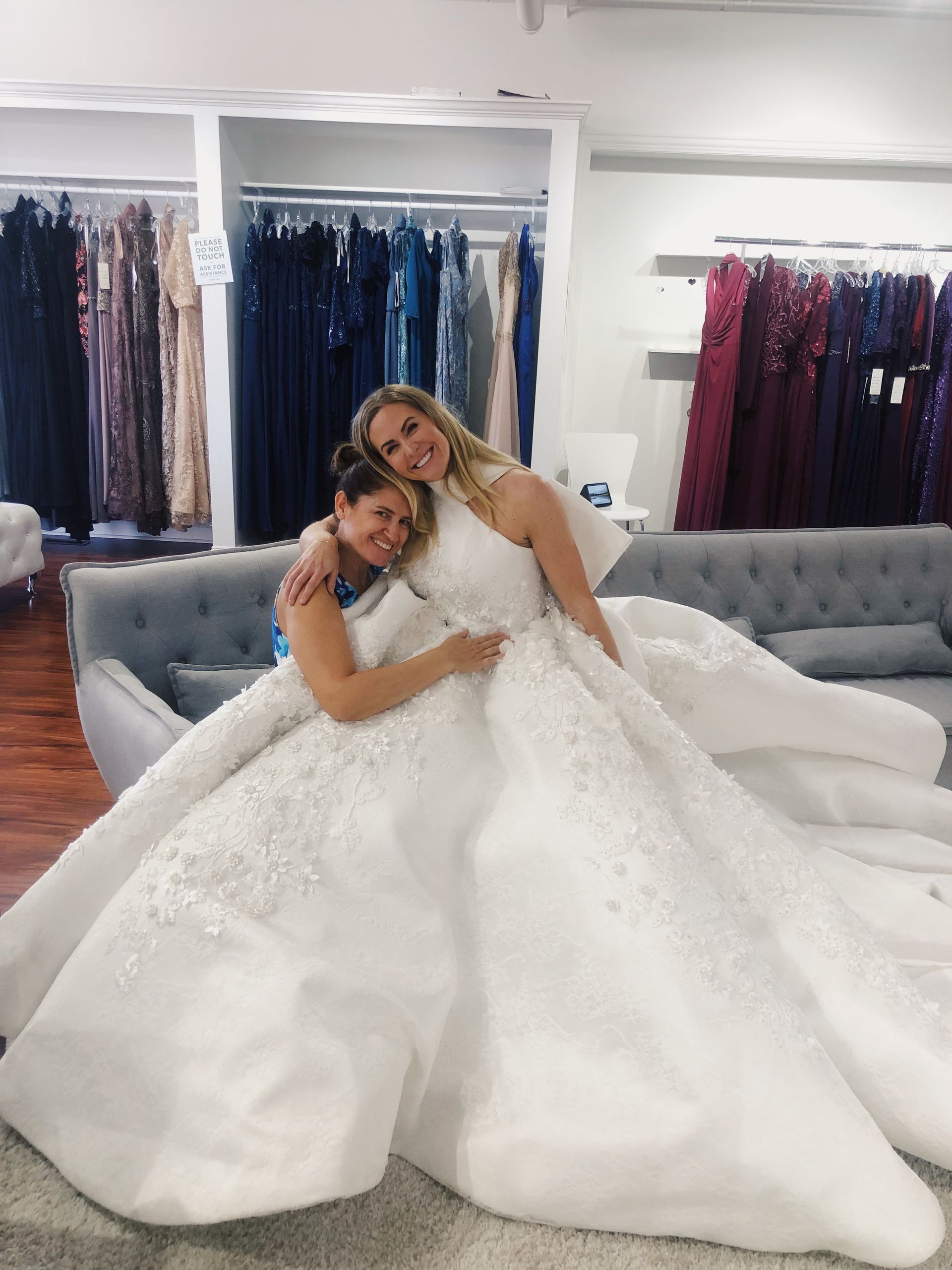 Two women in wedding dresses are posing for a picture