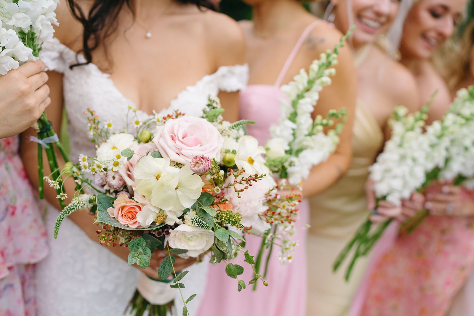 A bride and her bridesmaids are holding bouquets of flowers.