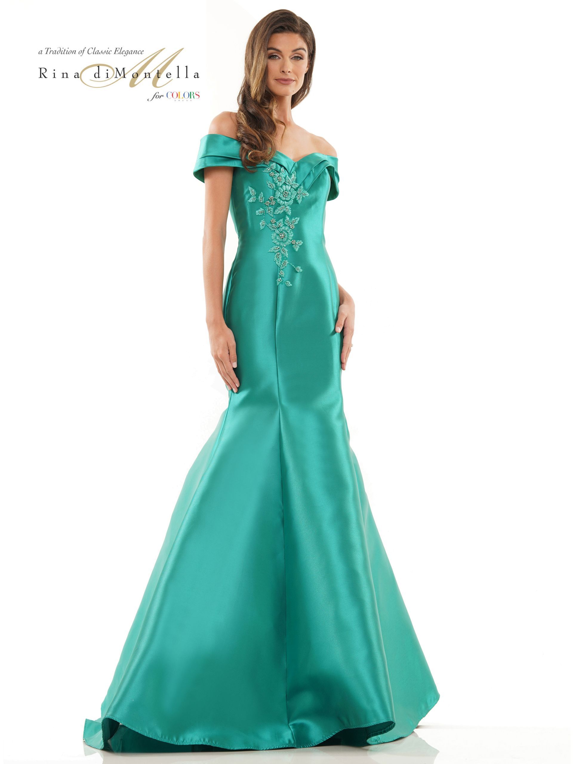 A woman is wearing a green off the shoulder dress.
