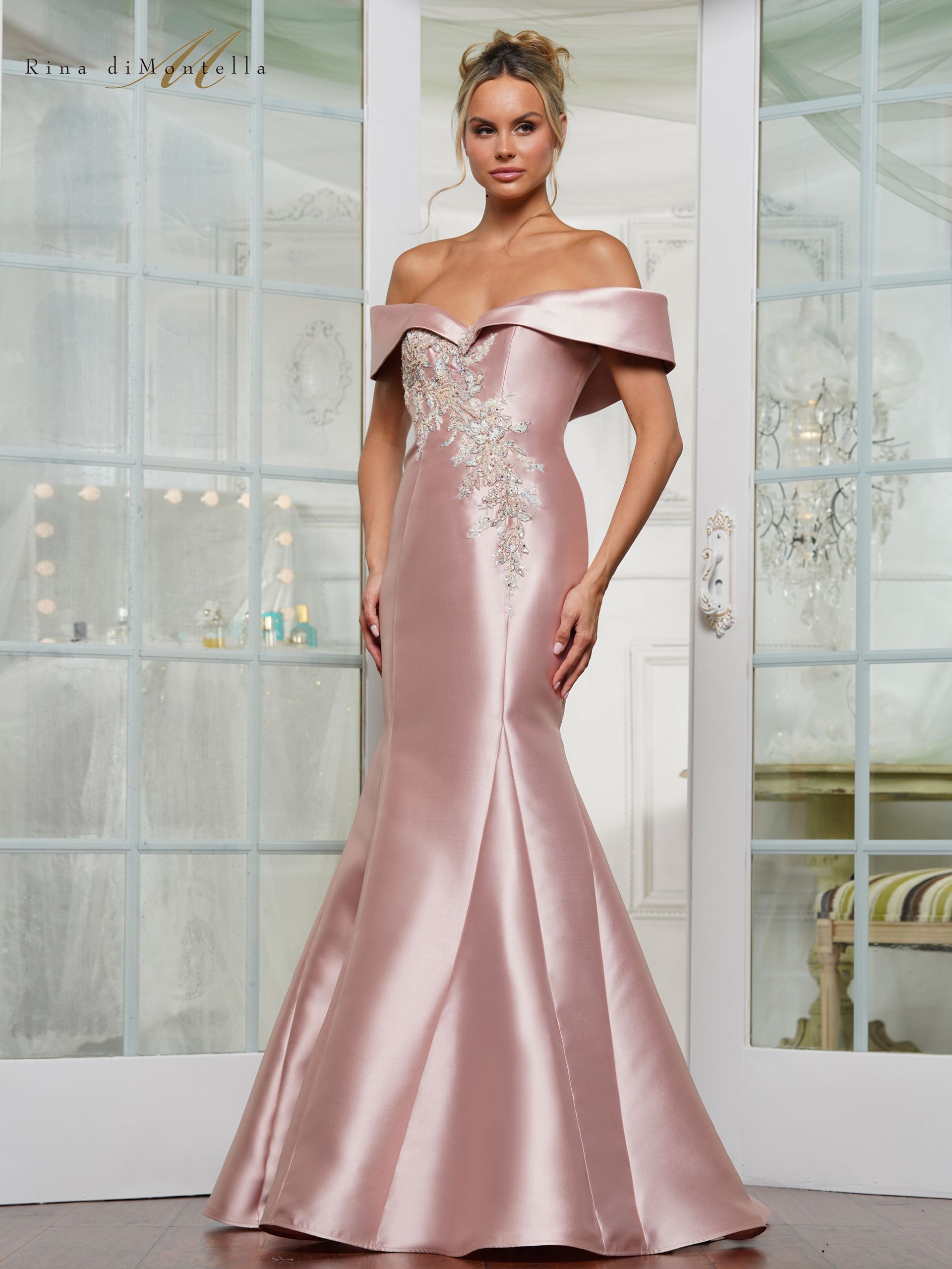 A woman is wearing a pink off the shoulder dress