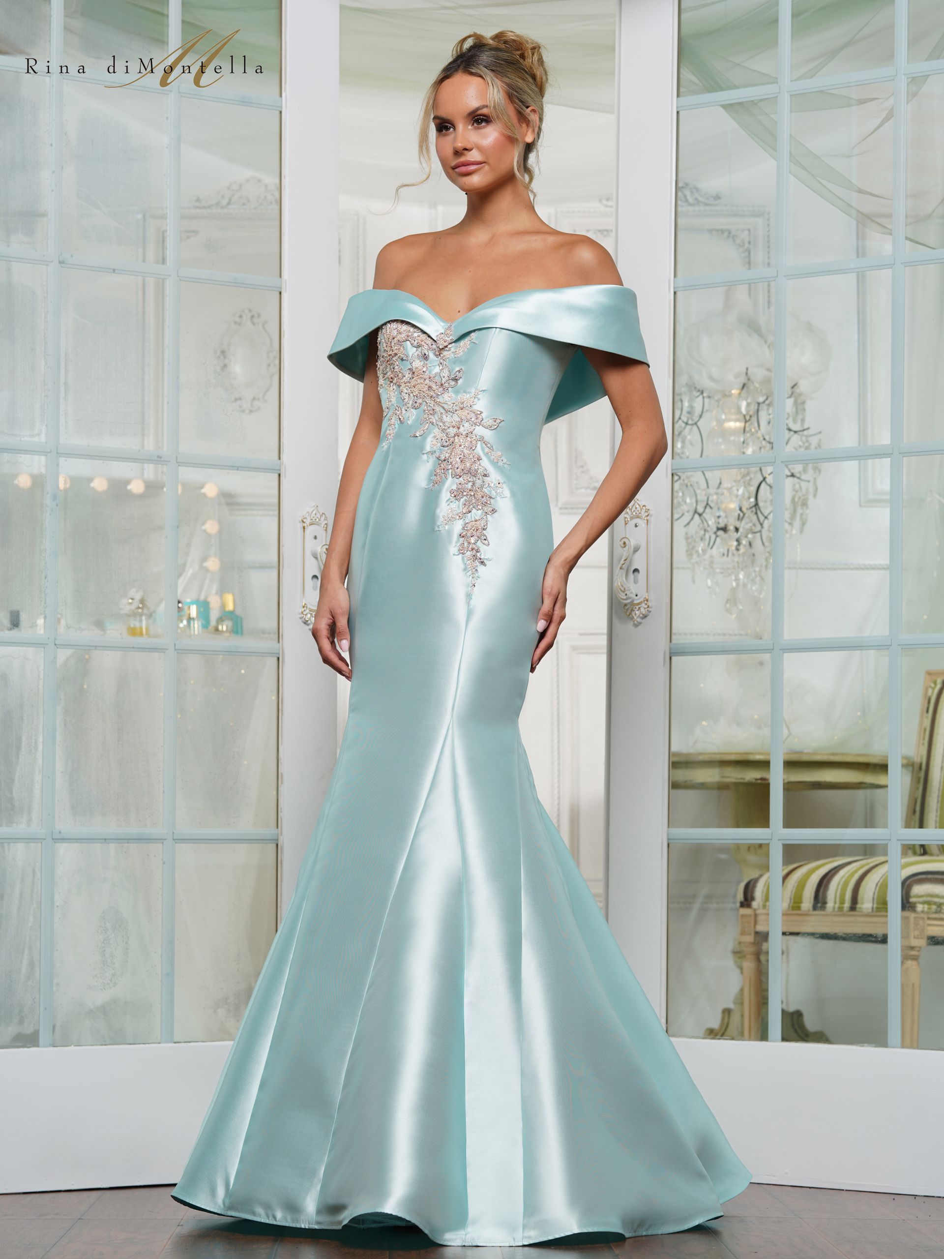 A woman is wearing a light blue off the shoulder dress.